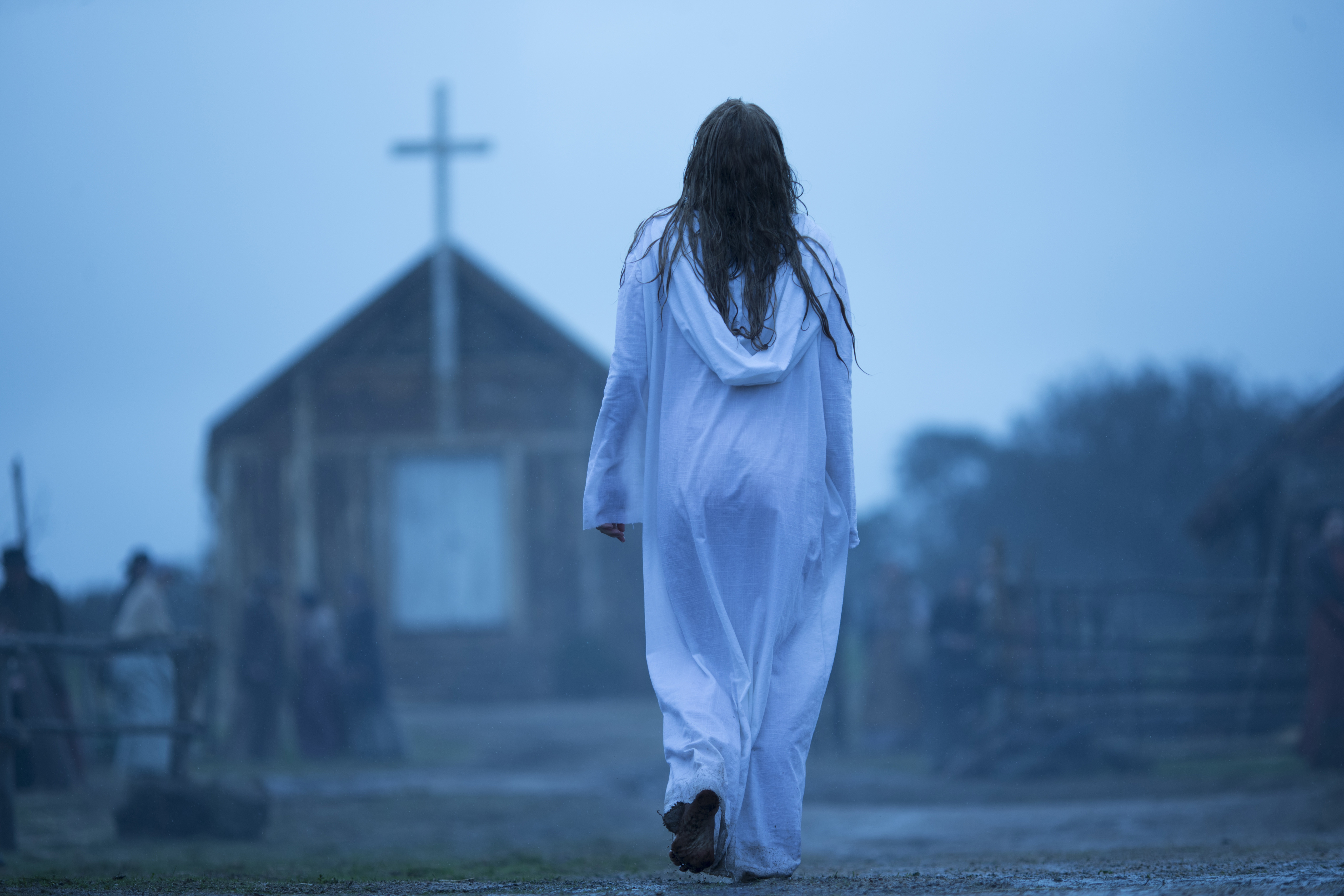 A woman in a white robe approaching a church, representing spiritual seeking in The Leftovers.