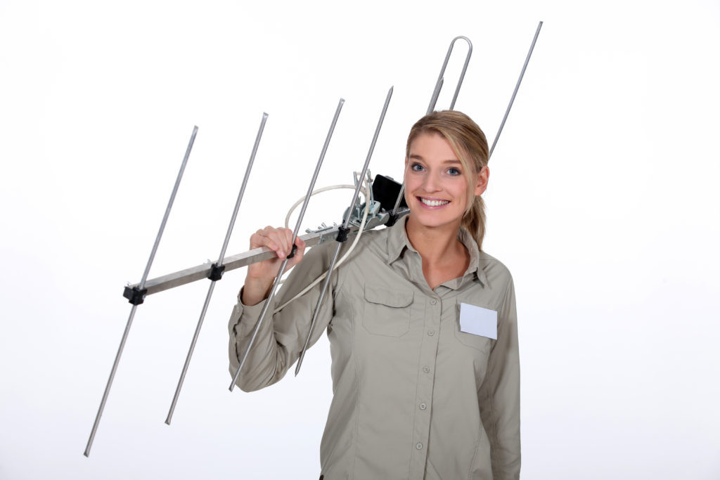 Technician installing a TV antenna on a roof.