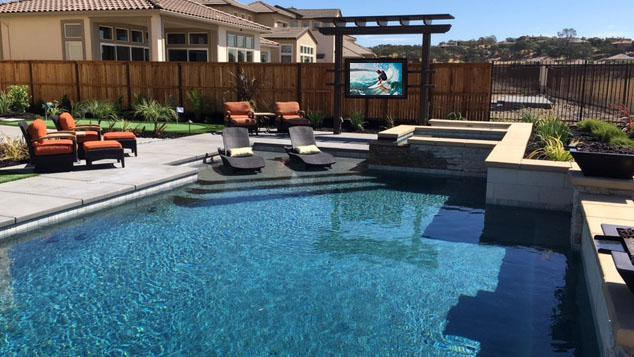 Outdoor TV cabinet by pool in backyard