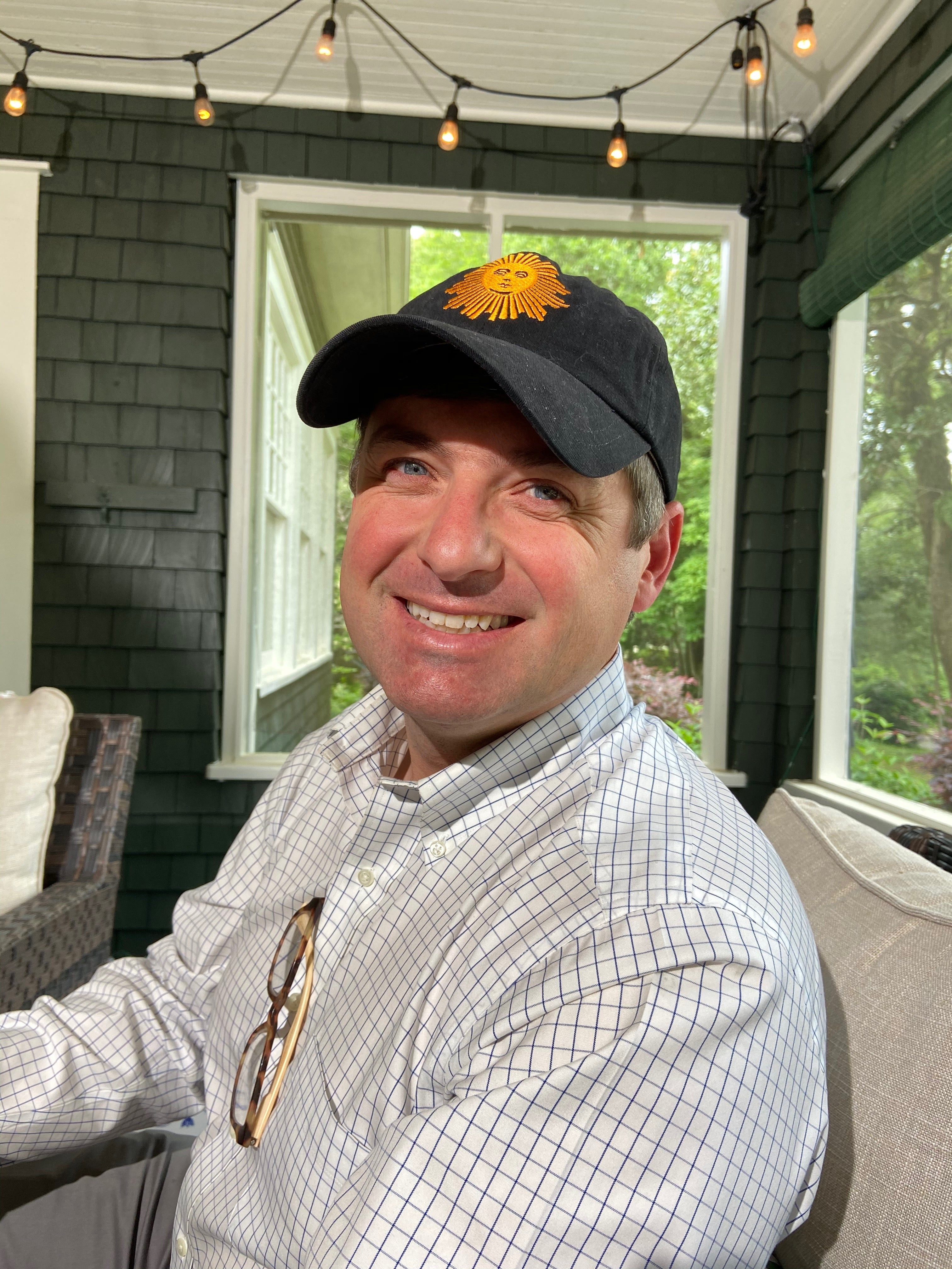 Jim Rasberry sits on his front porch smiling.