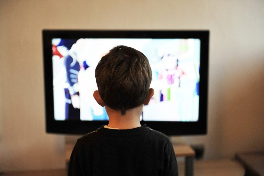 A family gathered around a modern television, enjoying a program together.