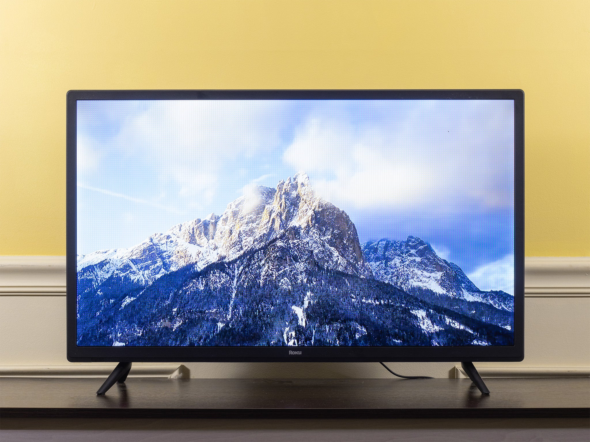 A Roku Select Series HD (32R3B5) displaying a mountain scene.