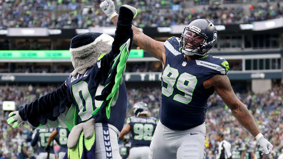 Seattle Seahawks player reacting with mascot Blitz at Lumen Field