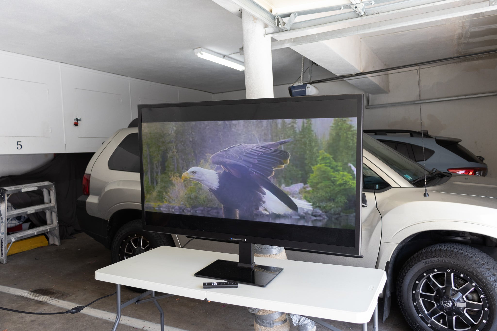 The SunBriteTV Veranda 3 Series Outdoor Smart TV, sitting on a table in a garage.