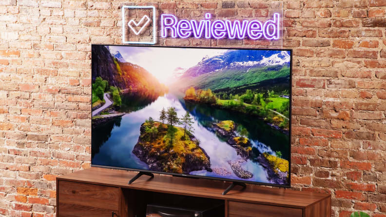 The Hisense U6K Mini-LED TV on a table with a brick background