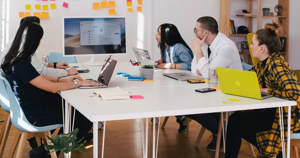 People in a business meeting analyzing market data on a screen.