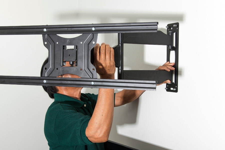 Man standing in front of a mounted TV